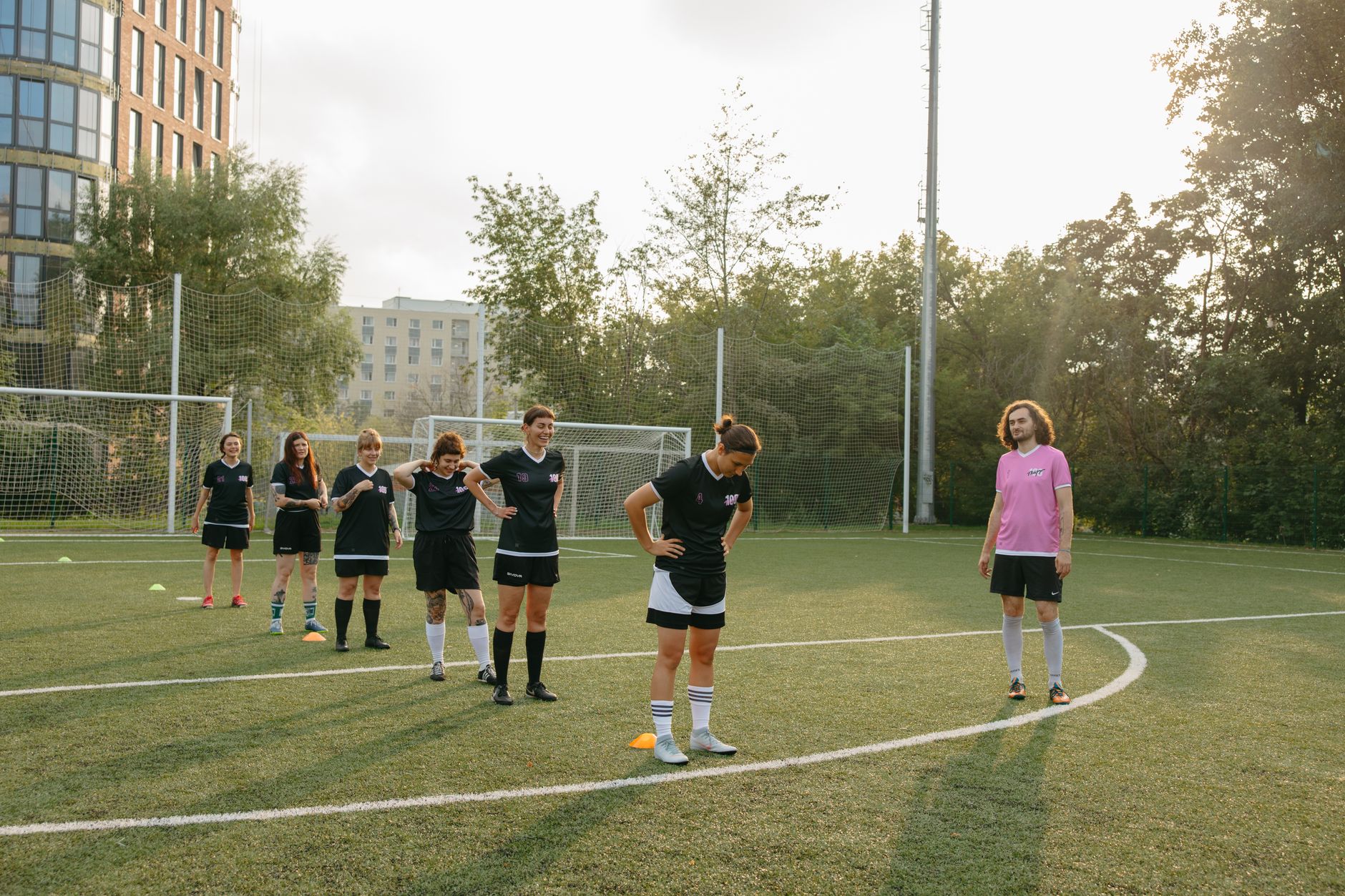 Soccer team and coach gathering on a training field.