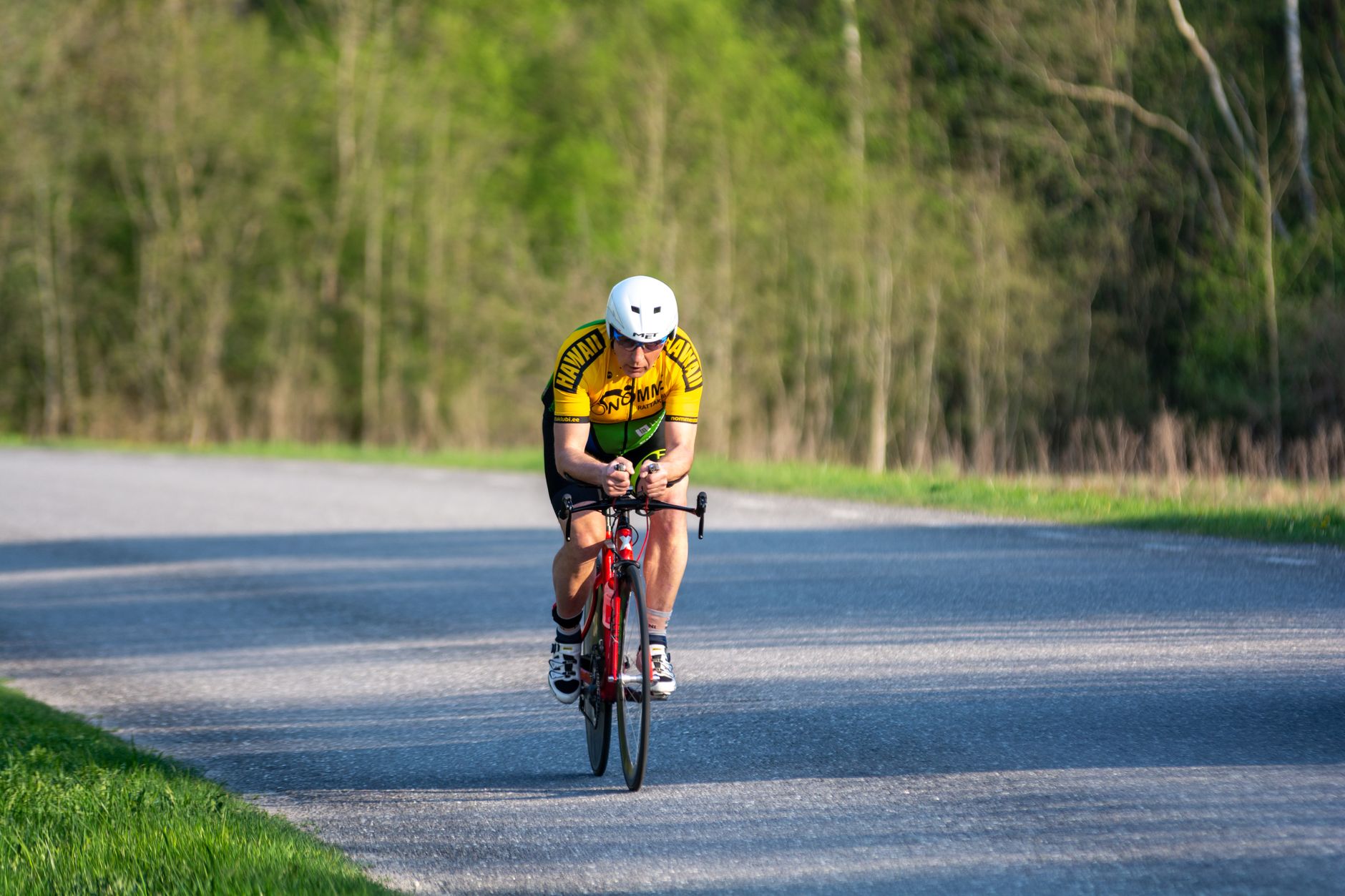 Triathlete riding in an aerodynamic position on an open road.