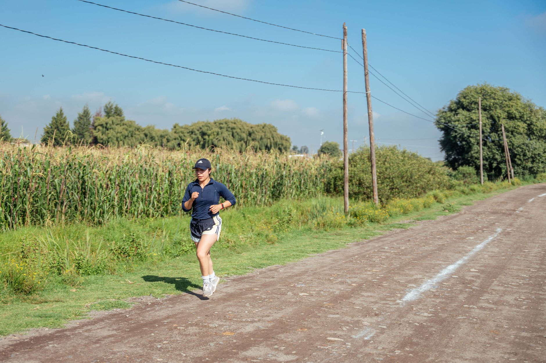 Runner holding a steady effort on a quiet rural road.