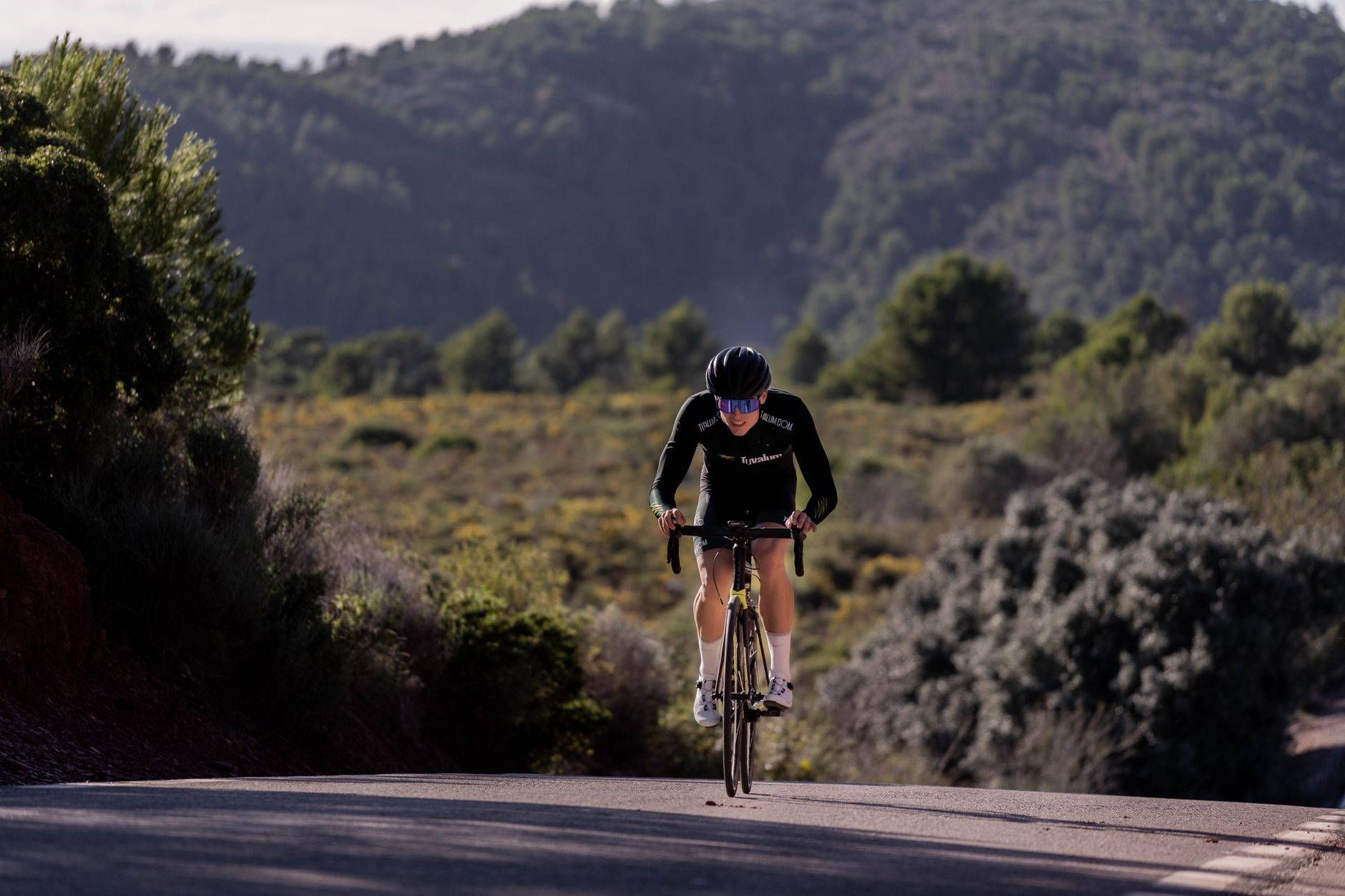 Cyclist climbing a road during race preparation training.